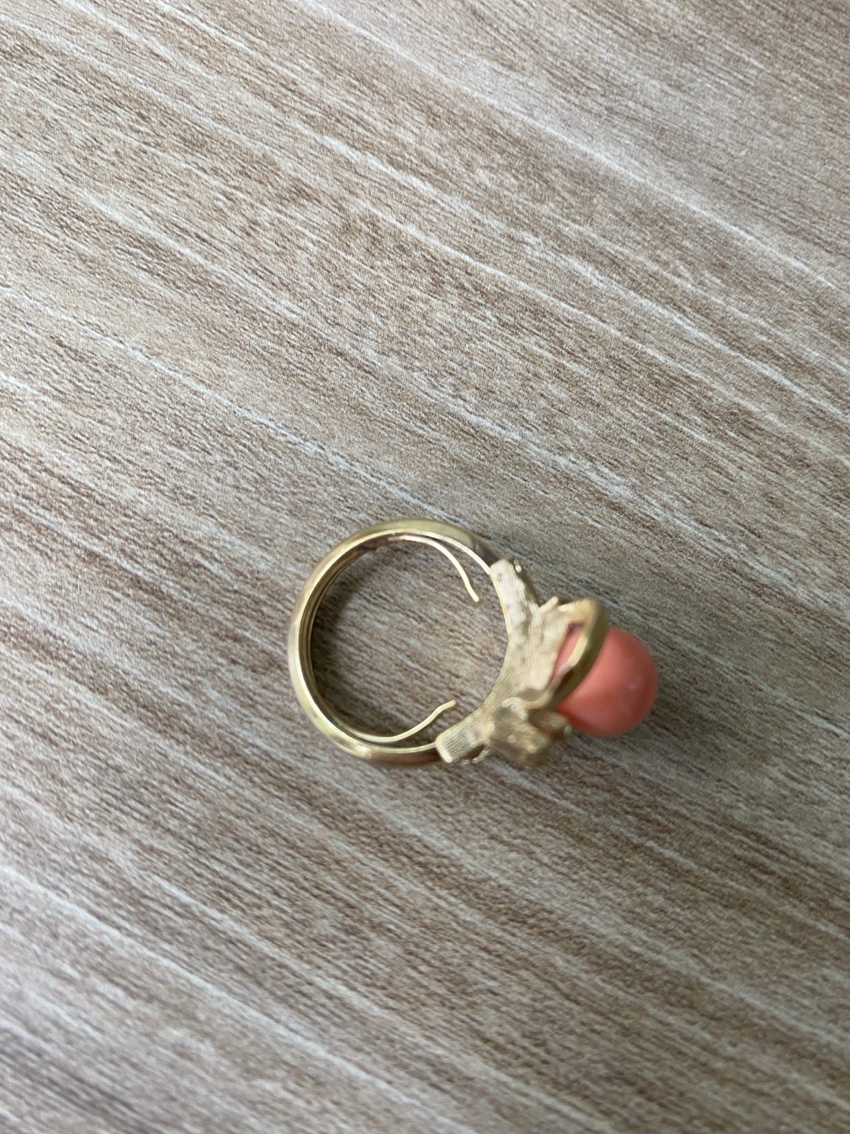 Avon vintage gold toned ring showcasing a single faux coral-colored bead.