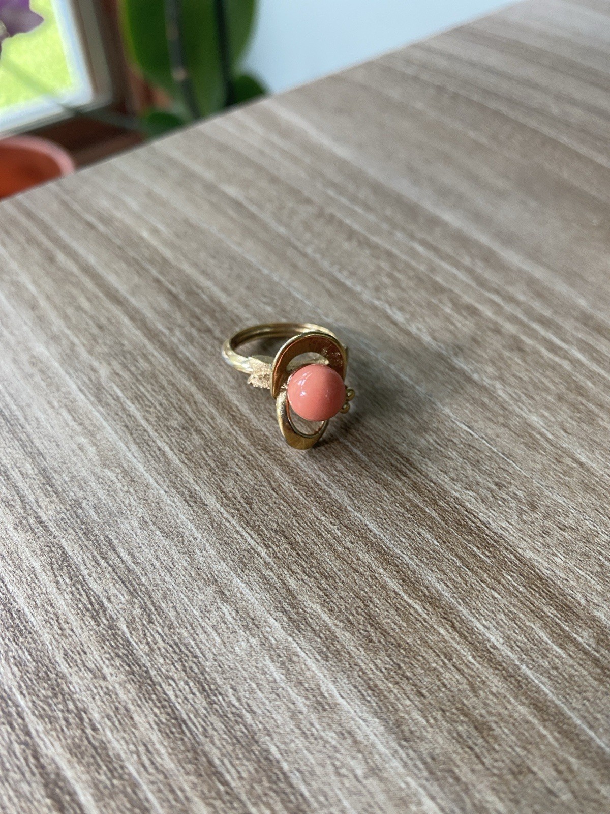 Avon vintage gold toned ring showcasing a single faux coral-colored bead.